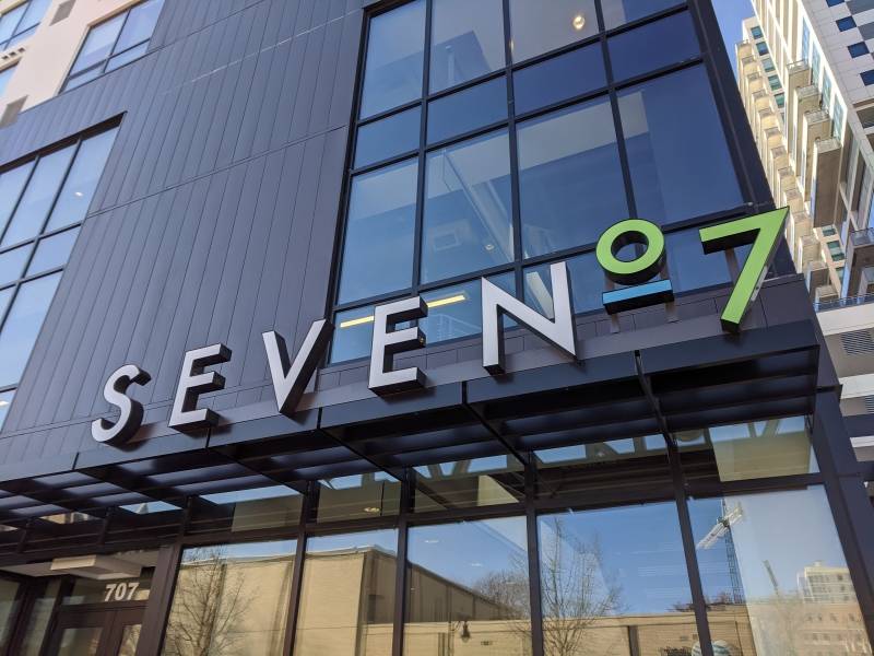 Image: A close of of the S E V E N 0 7 sign. The letters are in white and the numbers are in green.