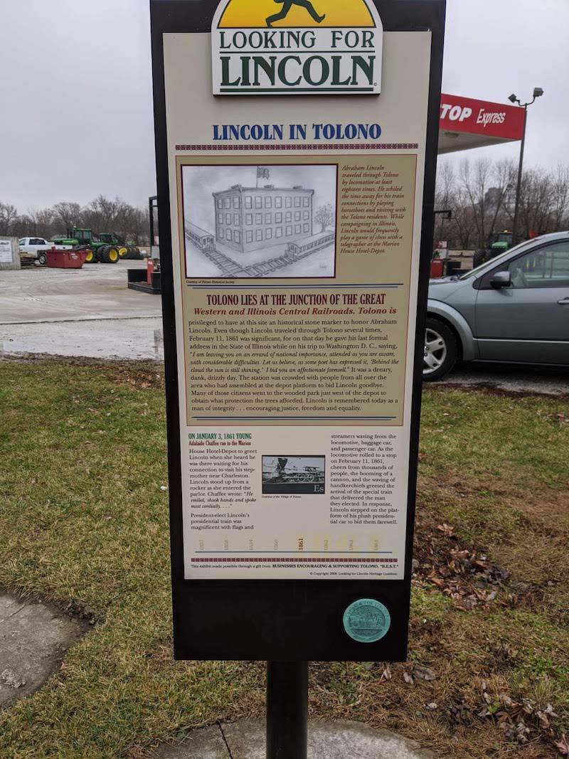 Image: An informational panel title Lincoln in Tolono. It is framed in black and surrounded by grass. Photo by Alyssa Knights.