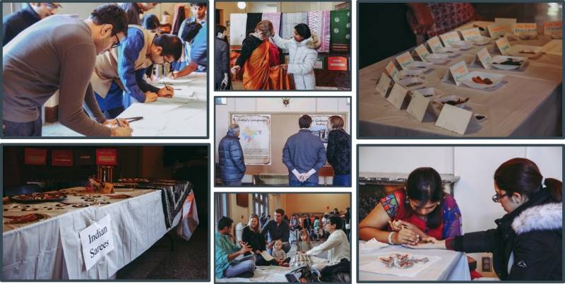 There are several images of cultural exhibits set up in Foellinger Auditorium. They include a display of sarees, a tabel with food samples, a woman doing henna, and people looking at a bulletin board, and a family sitting on the ground listening to musicians play. Image from Facebook event page.