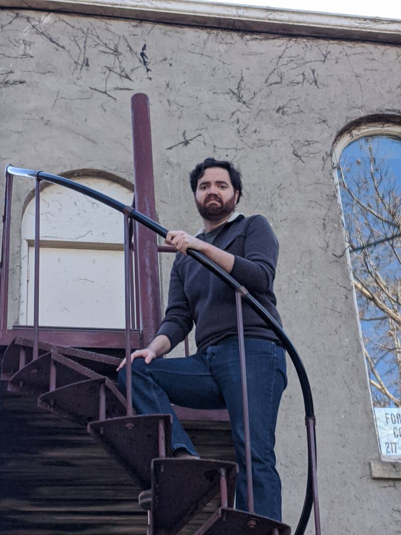 Image: The writer is standing at the top of the metal spiral staircase and frowning. Photo by Andrea Black. 