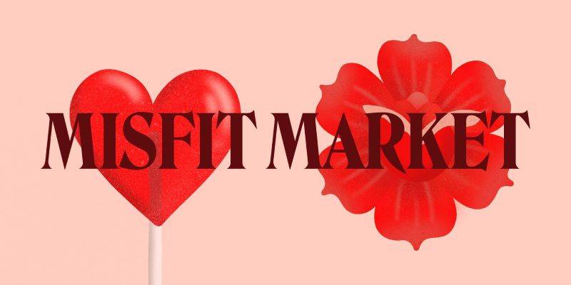 A poster with a light pink background. There is a red heart-shaped lollipop and a red flower. The words Misfit Market are in the center. Image from Facebook event page.