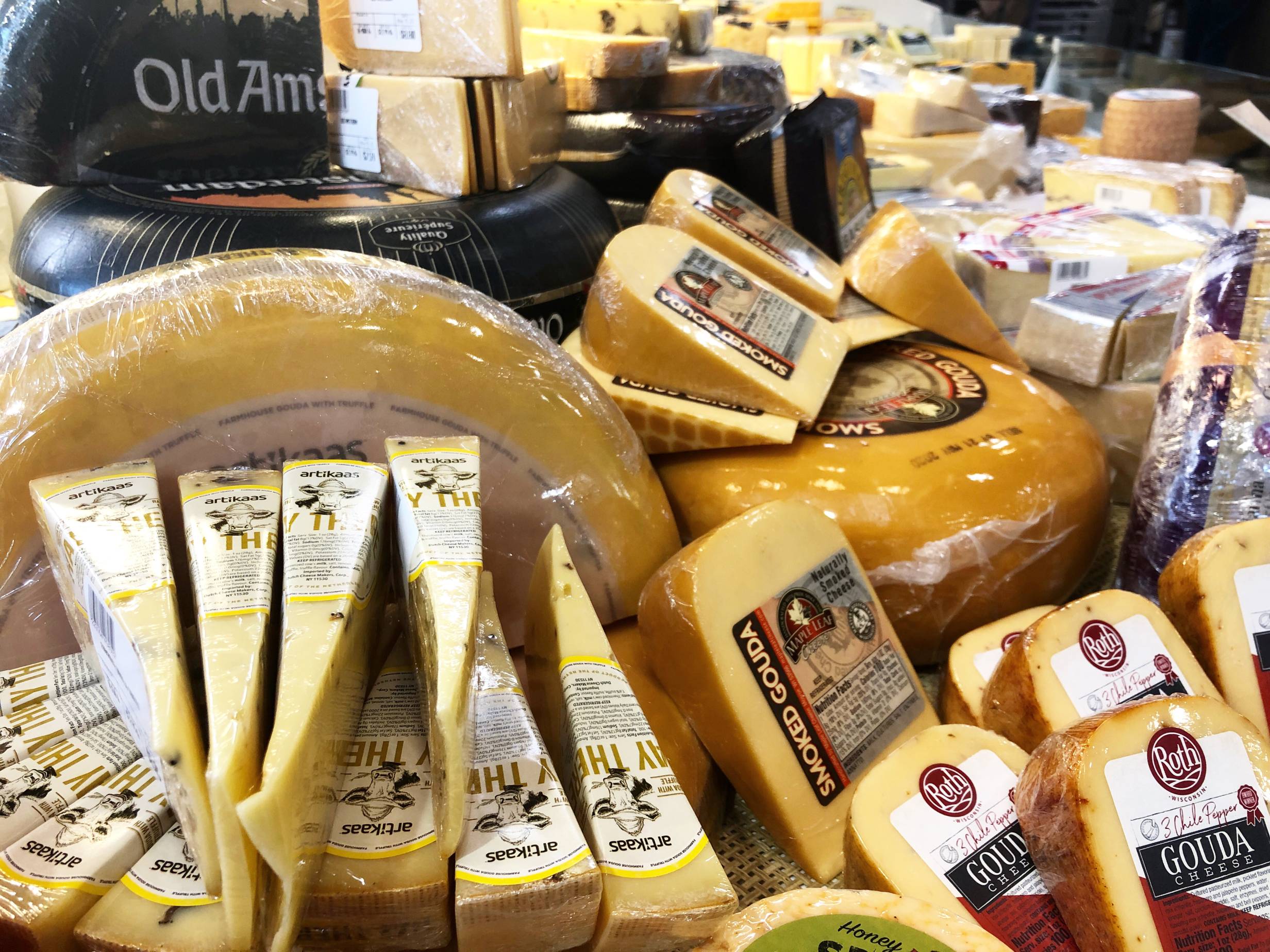 A close up of the gouda cheese section. There are several skinny wedges of cheese, a few wheels of cheese, and a collection of gouda cheese in the bottom right. Photo by Alyssa Buckley.