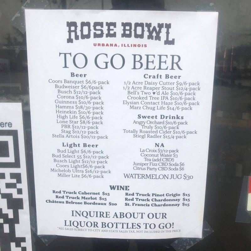 A white 8.5 by 11 piece of paper with a listing of beverages for sale. It is taped to a glass door. 