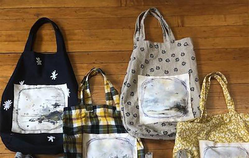 Image: Photo of multiple fabric totes featuring art by Carol Farnum. Photo from Circles website.