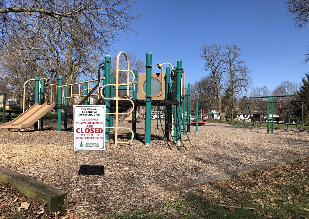 Clark Park playground. A sign on the edge of the mulched playground area says 