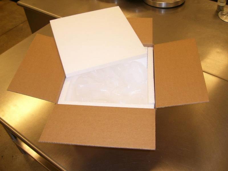 A cardboard box is sitting on a counter with the flaps open. There is a pack of dry ice inside. Photo provided by Papa Del's. 