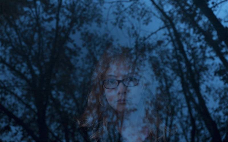 Image: Photo of woman's face fading behind nighttime treescape. Photo from Instagram