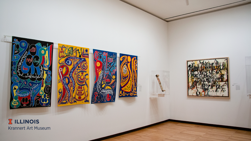 An art gallery with white walls. There are brightly colored art panels hanging along the wall. Photo from Krannert Art Museum. 