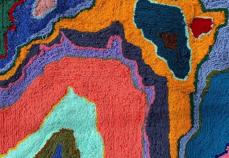 Image: Detail from photo of Kelly Hieronymus' tufted yarn work featuring a broad range of colors and organic shapes. Photo from Boneyard Arts Festival Facebook page.