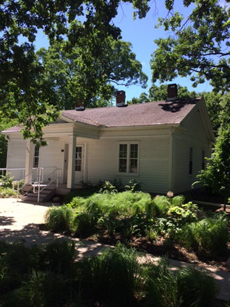Photo of Leal Park cottage. Small white clapboard building with gabled roof and small entry portico. Photo by Rick D. Williams.