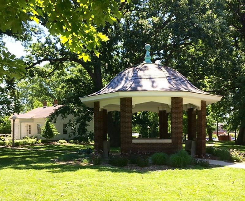Photo of Leal Park gazebo. Circular with brick lower wall 4' high topped by 6 brick columns, 6' high each. Frame domed roof with shingles.  Photo by Rick D. Williams.