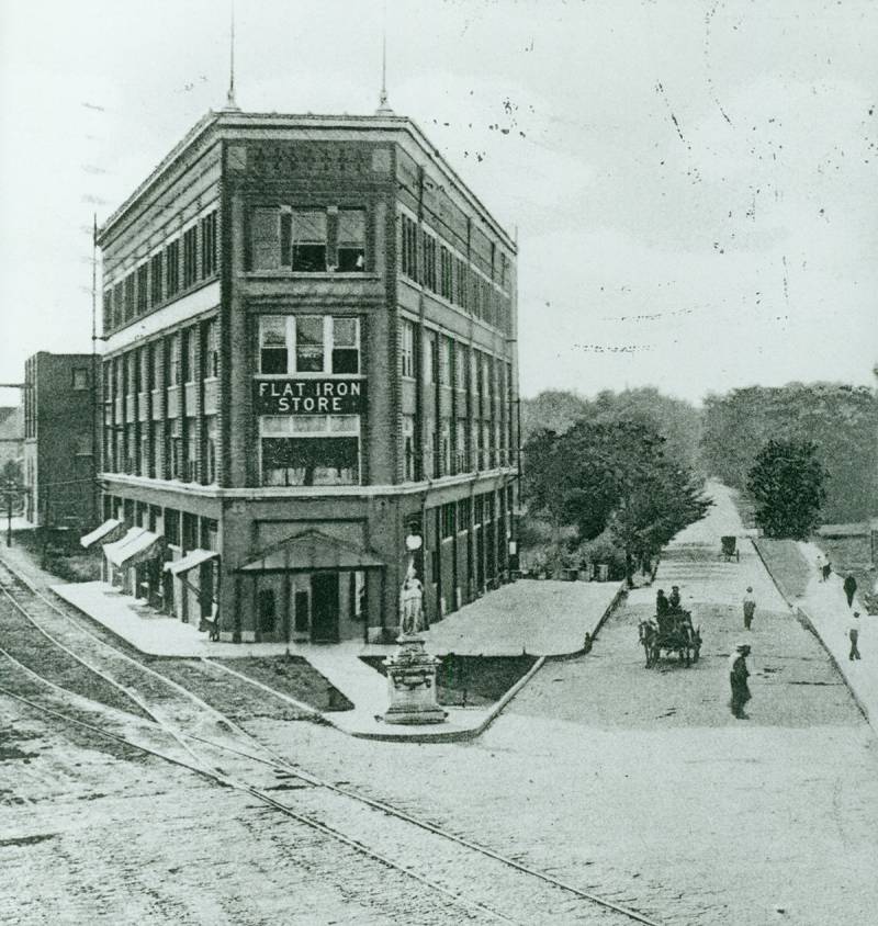 Black and white photo looking to the west.  Main street and Springfield avenue split with Main taking a northwest angle.  The four story brick building sits in the angle between the two streets.  Photo from Urbana Unit District 116 online 