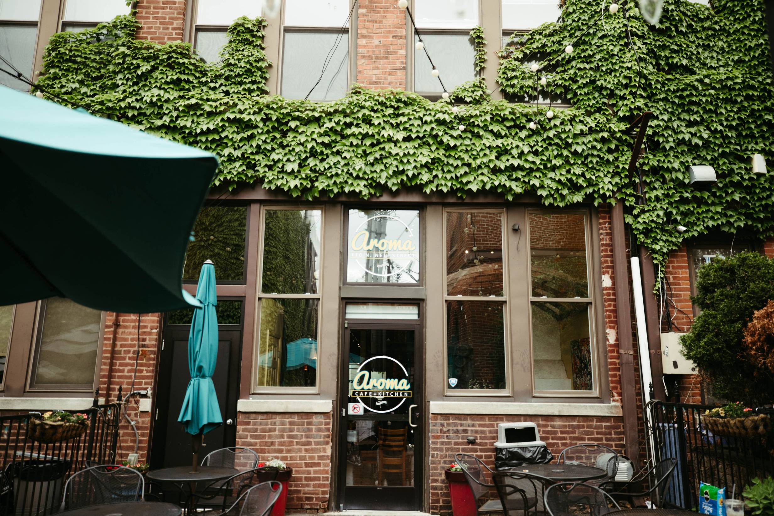 The exterior of Aroma Cafe with lots of greenery. Photo by Anna Longworth.