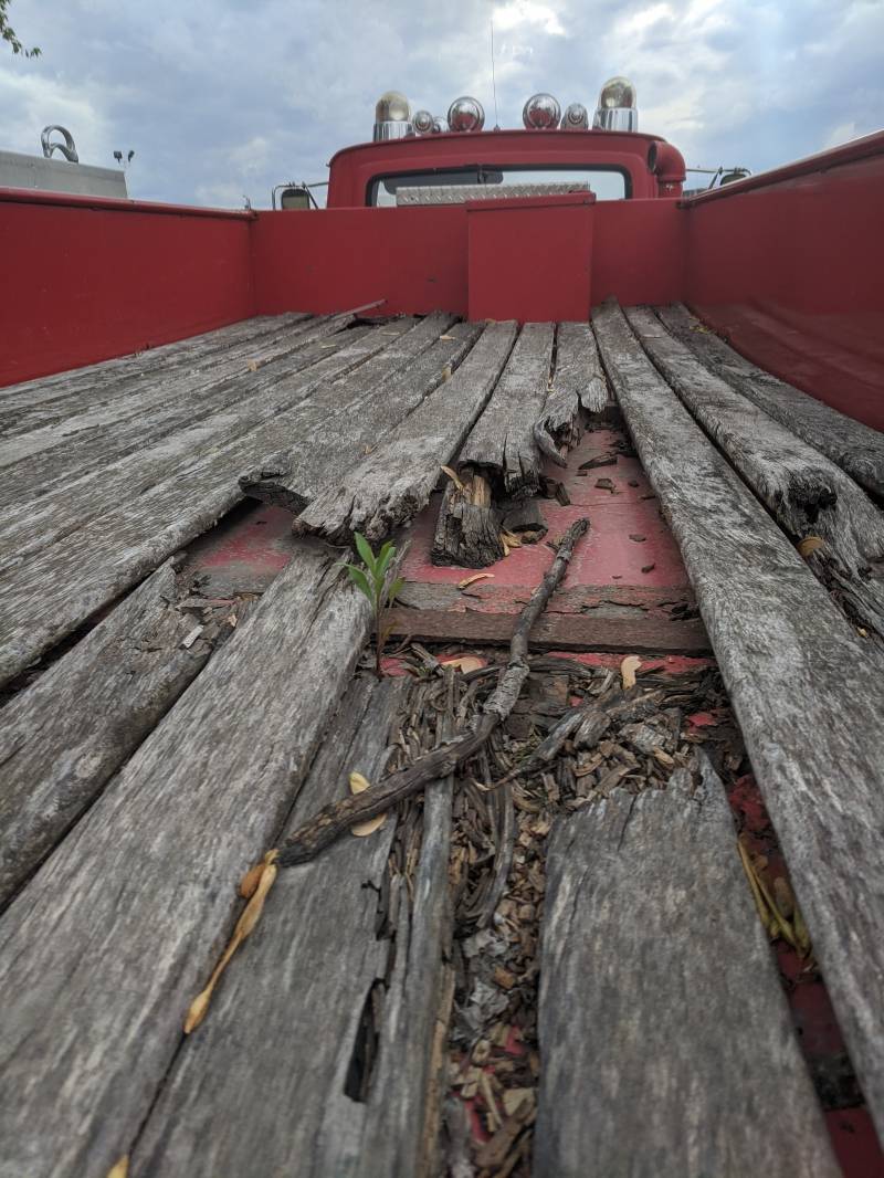 The interior of a fire truck bed. It is lined with old wood planks, some of which are broken. Photo by Tom Ackerman.