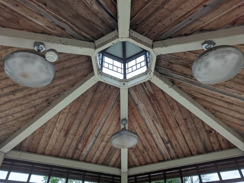The interior of the roof of the gazebo. There is a small dome in the center, and three lights hanging from the ceiling. Photo by Tom Ackerman.
