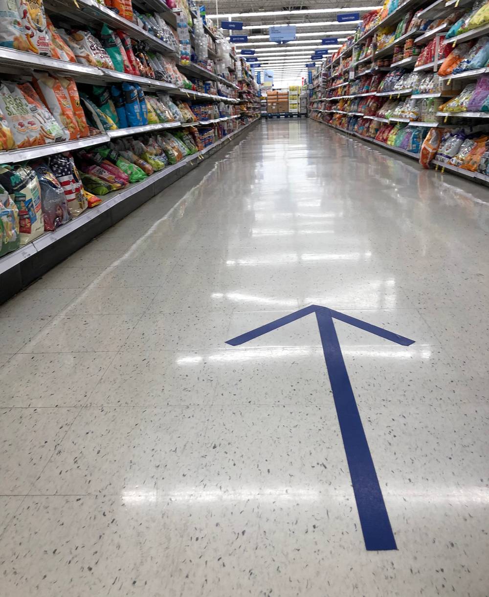 Blue arrow on the floor at Meijer, indicating which direction traffic should move in the grocery aisle. Photo by Jessica Hammie. 
