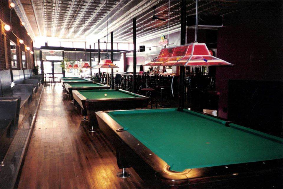 An interior of Jupiter's Downtown with four billiards tables and seating alongside the left side of the photo, bar on the right. Photo from Jupiter's Facebook page.