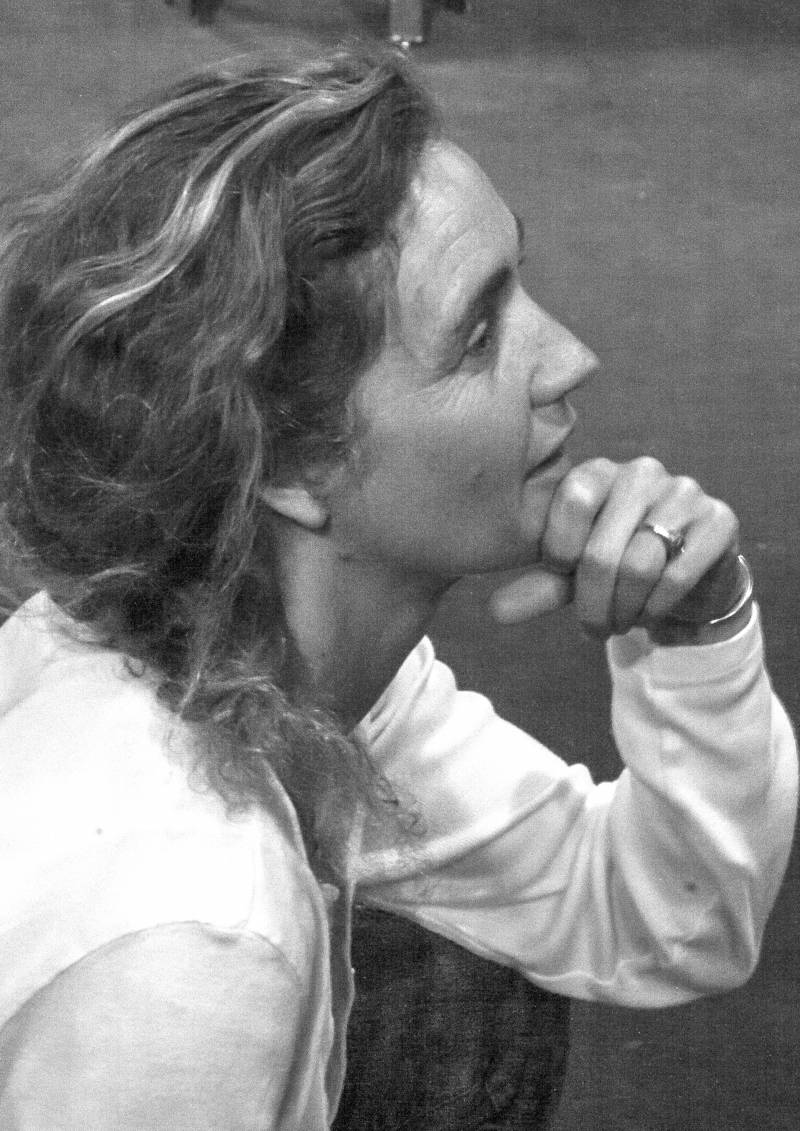 A black and white photo that shows the profile of a woman with wavy hair. Her chin is propped on her fist. Photo by Mark Sullivan. 