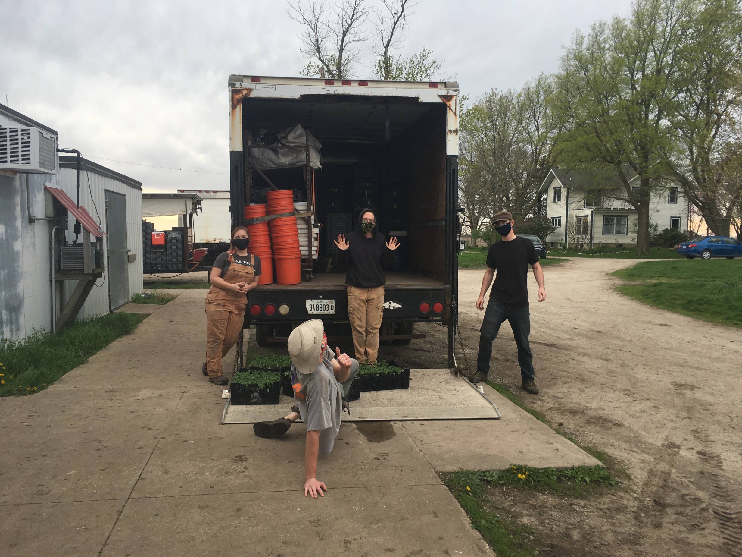  The 'masked crew' jumps on a truck to move some crops amid this COVID-19 virus. Photo by Blue Moon Farm.