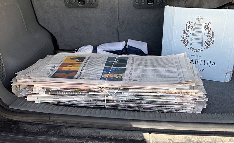 Folded and bundled newspaper are pictured in the trunk of a car. Photo by Debra Domal. 