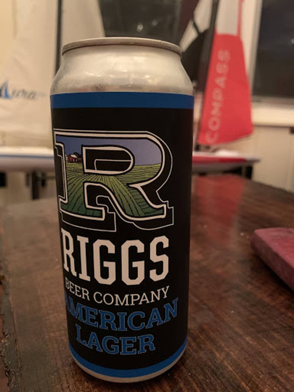A can of Rigg's Beer Company American Lager sits on a wood table. Photo by Lindsay Aikman. 