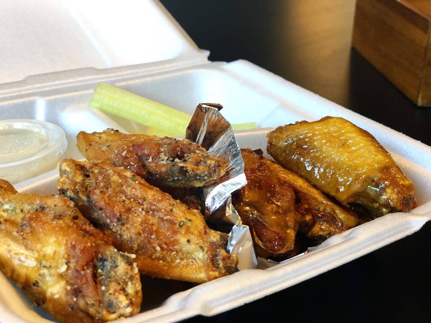 Ten wings with two different sauces inside a styrofoam container. Photo by Alyssa Buckley.