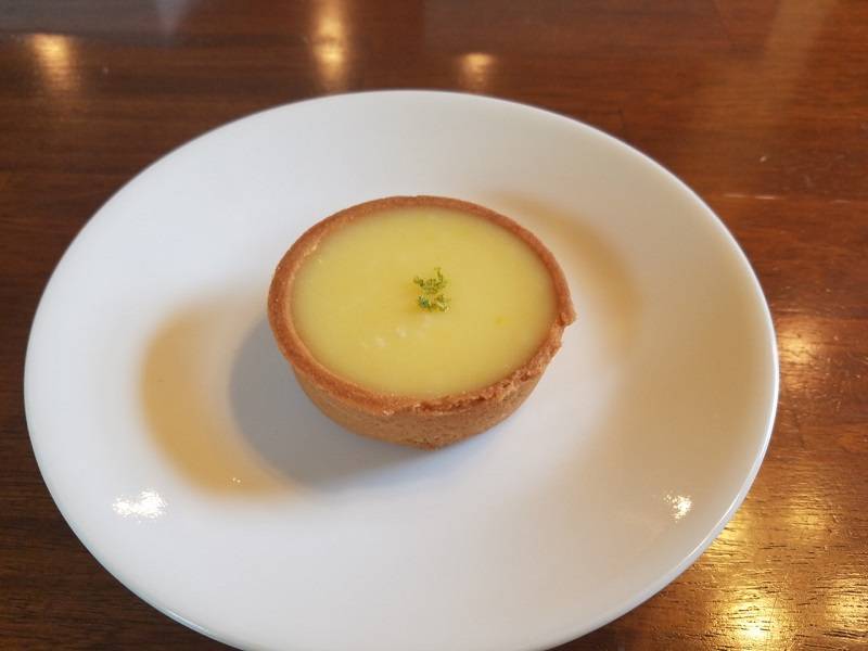 Bright yellow lemon tart with tiny shavings of lime on top. Photo by Matthew Macomber.