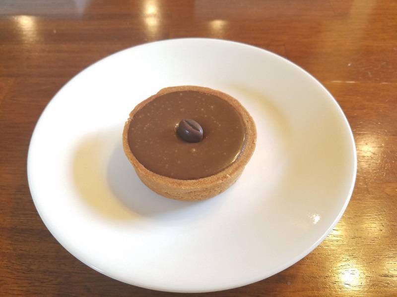 Light brown mocha tart with a chocolate covered coffee bean on top. Photo by Matthew Macomber.