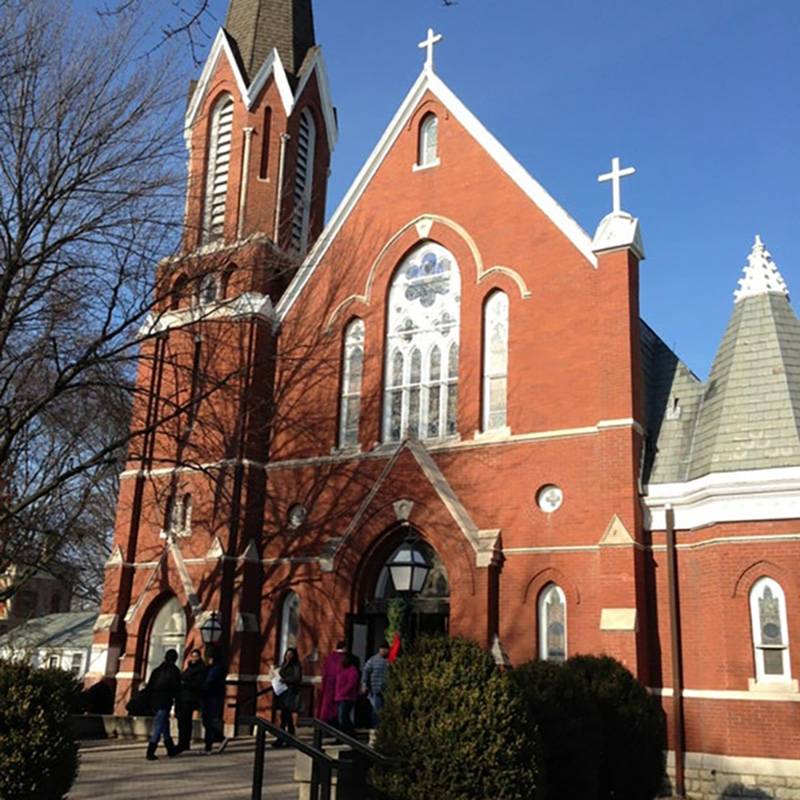 St. Patrick's Church, taken facing north toward the original entrance on Main Street. Red brick, tower toped with tall steeple on southwest corner. Turret on opposite corner. Center gabled roof with arched entry below. Photo by Rick D. Williams.