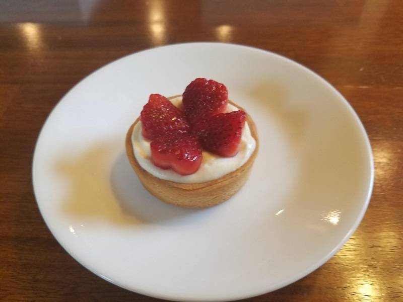 Strawberry tart with one strawberry neatly cut into quarters on top. Photo by Matthew Macomber.
