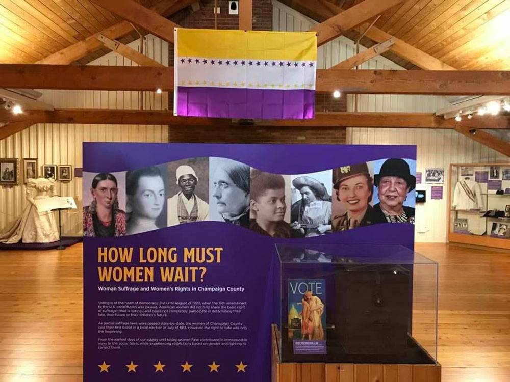 A purple poster board with several photos of women on the top, with the title 
