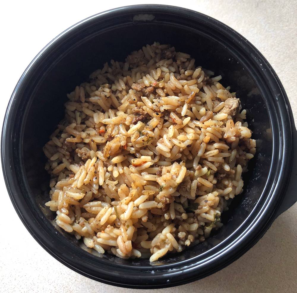 Dirty rice served in a black plastic take out container. Photo by Jessica Hammie. 