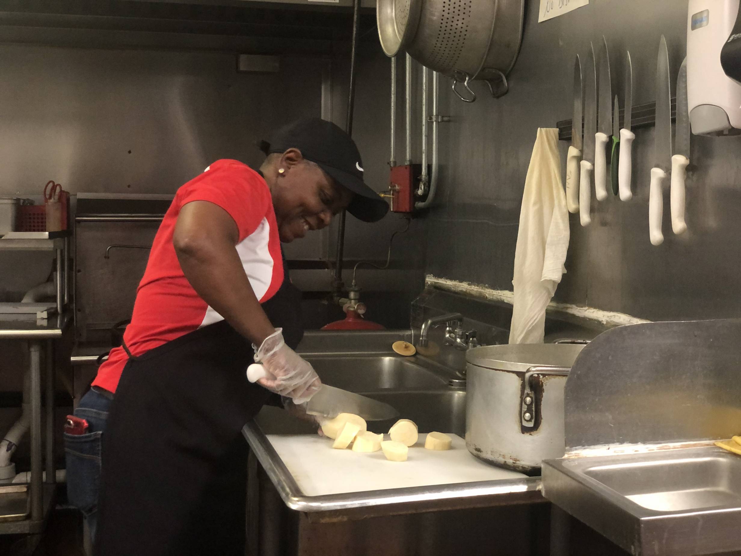Mubanga Chanda chops sweet potatoes in the Stango Cuisine kitchen. Photo by Alyssa Buckley.