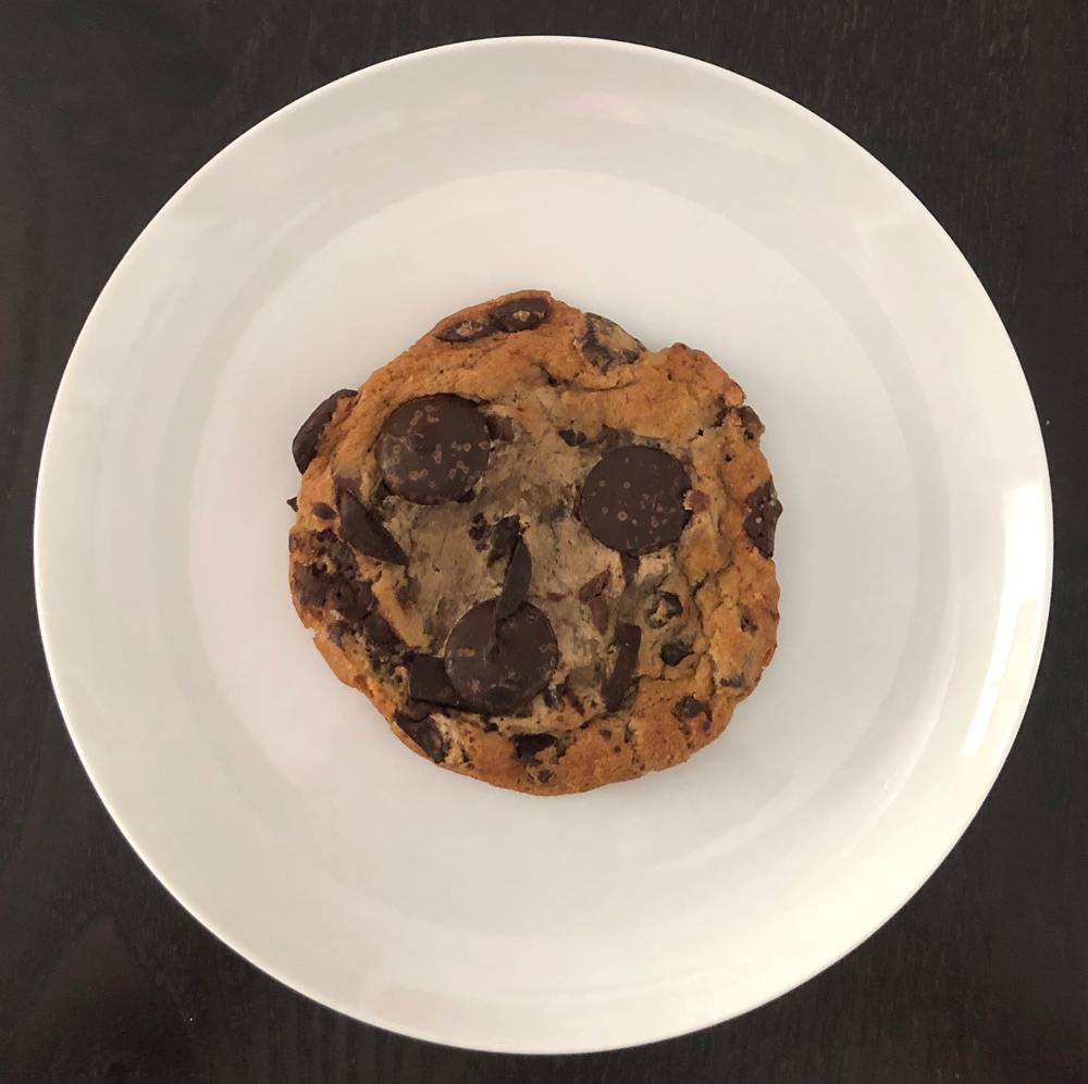A Manifesto Chocolate Chunk cookie on a salad plate. The cookie is large and has very big chocolate chunks in it.Photo by Jessica Hammie. 