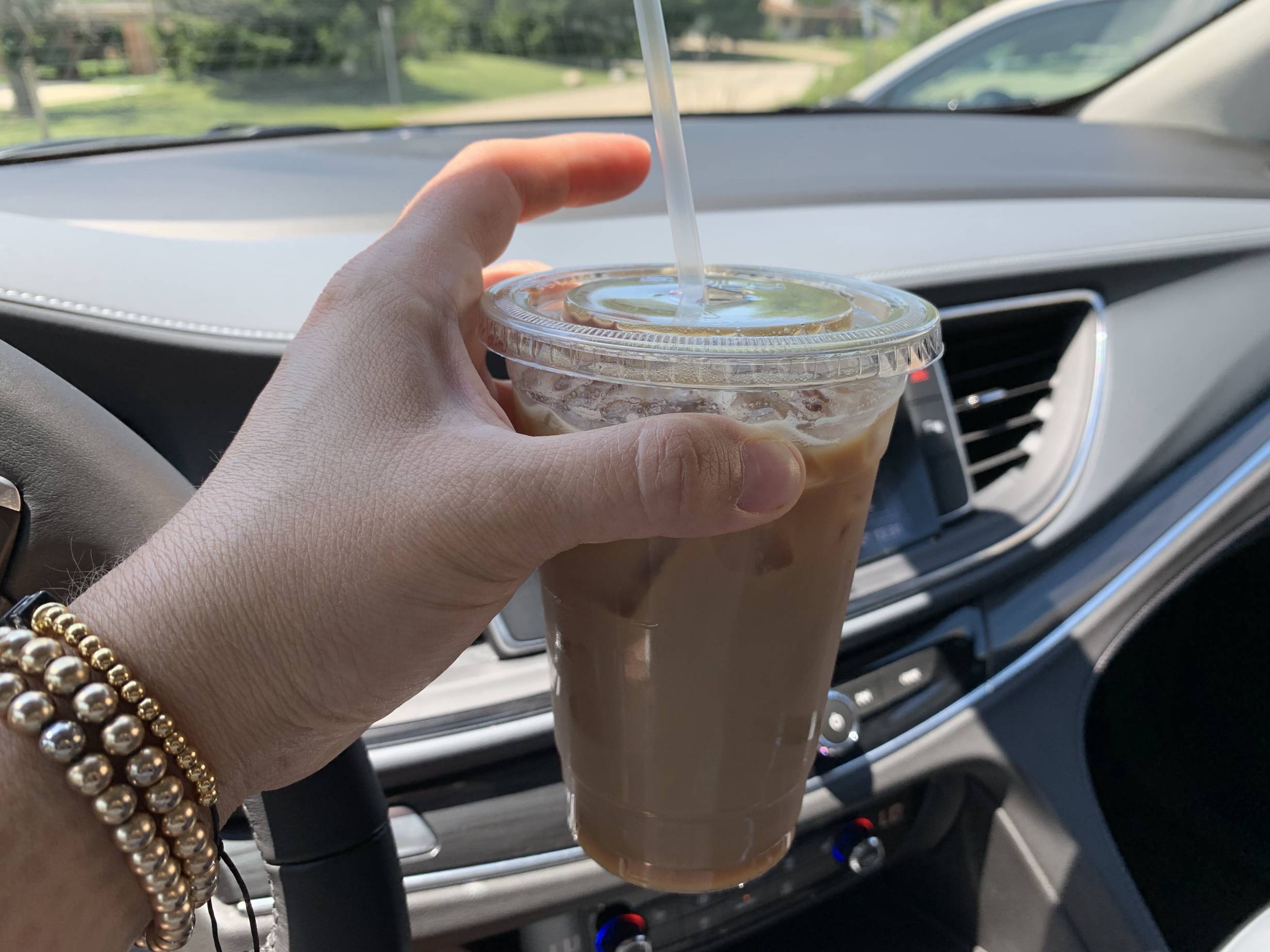 The author holds a large iced caramel latte with skim milk and caramel from Art Mart in her vehicle. Photo by Stephanie Wheatley.
