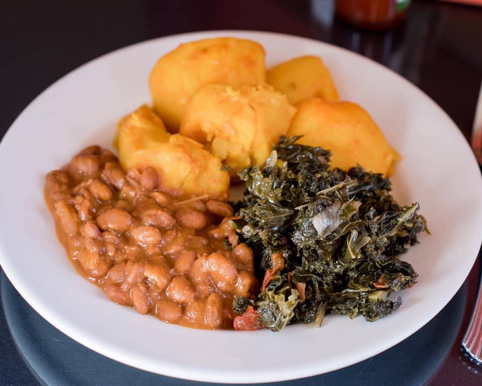A plate of Zambian food including beans, greens, and fluffy beef pies. Photo by Alyssa Buckley.