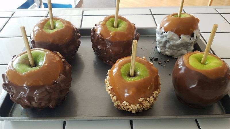 Apples dipped in caramel where some are also covered with nuts, white chocolate, and milk chocolate. Photo by CBPB.
