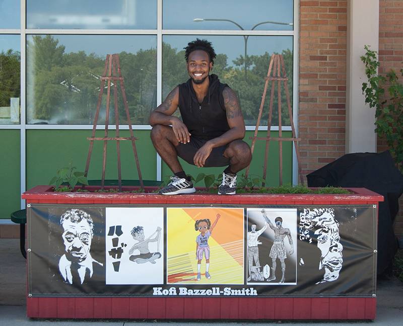 Artist Kofi Bazzell-Smith with his installation outside Common Ground Food Co-op
