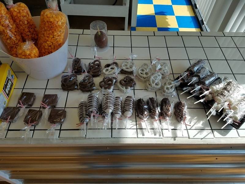 Chocolate-covered Twinkies, pretzels, and smores wrapped in plastic with ribbons on the CBPB counter. Photo by Matthew Macomber.