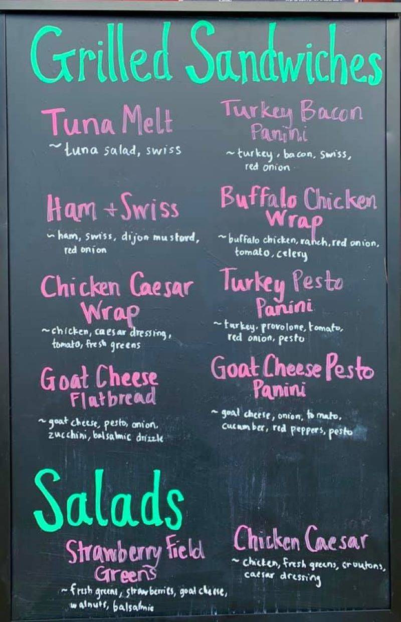 A black chalkboard menu board with text in green, pink, and white chalk. Photo from Espresso Royale Facebook page.