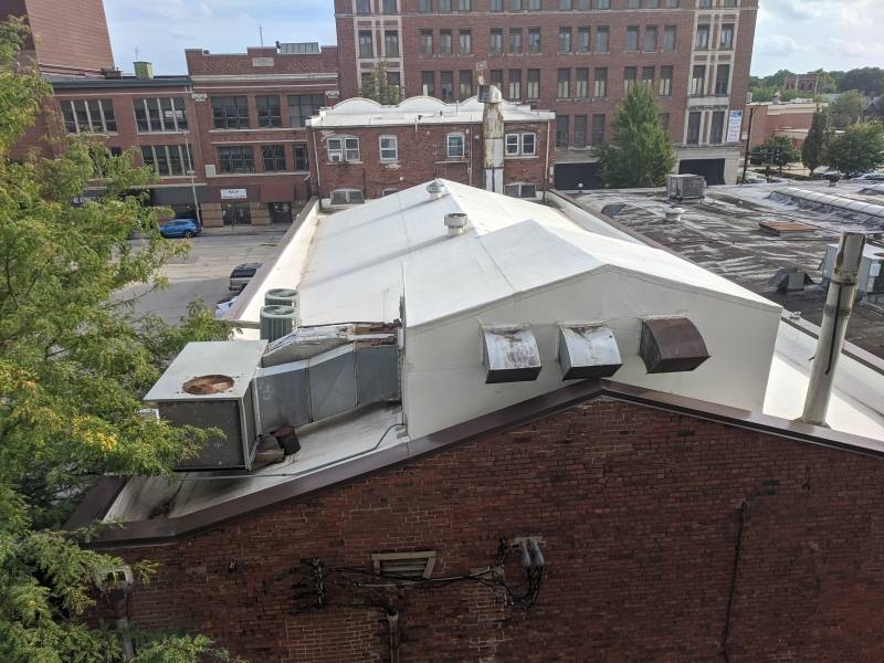 Another view of the rear of the theater, focused on the larger portion of the building that houses the actual theater. It has brown brick and a white roof. Photo by Tom Ackerman.