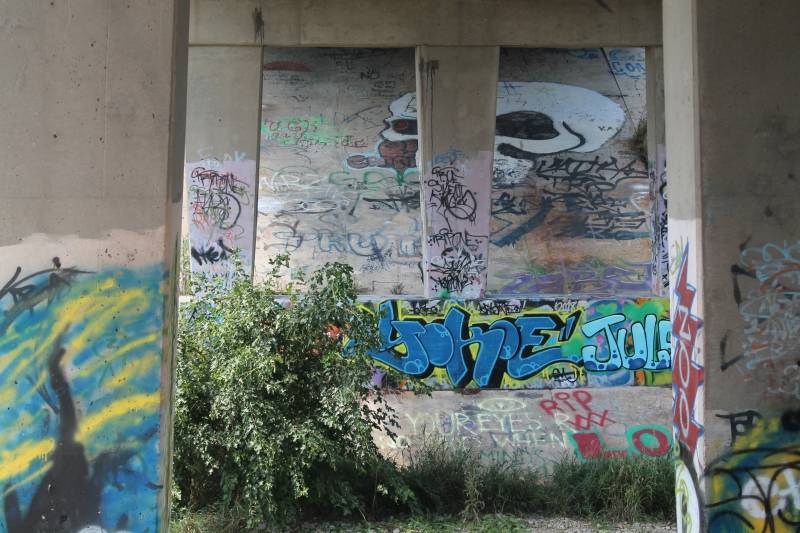 A picture of graffiti art under a bridge 