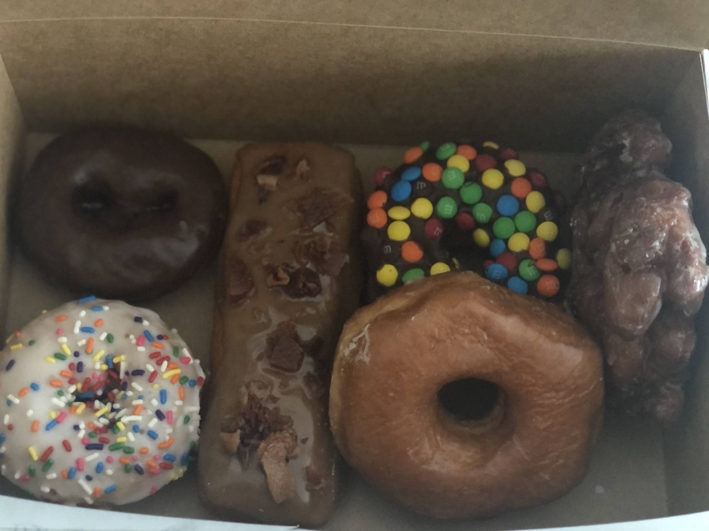 Six assorted donuts in a paper box. Photo by Alyssa Buckley.