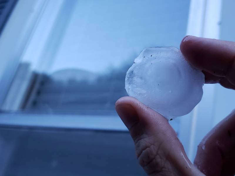 A close up of a hailstone held between two fingers. Photo by Andrew Pritchard.