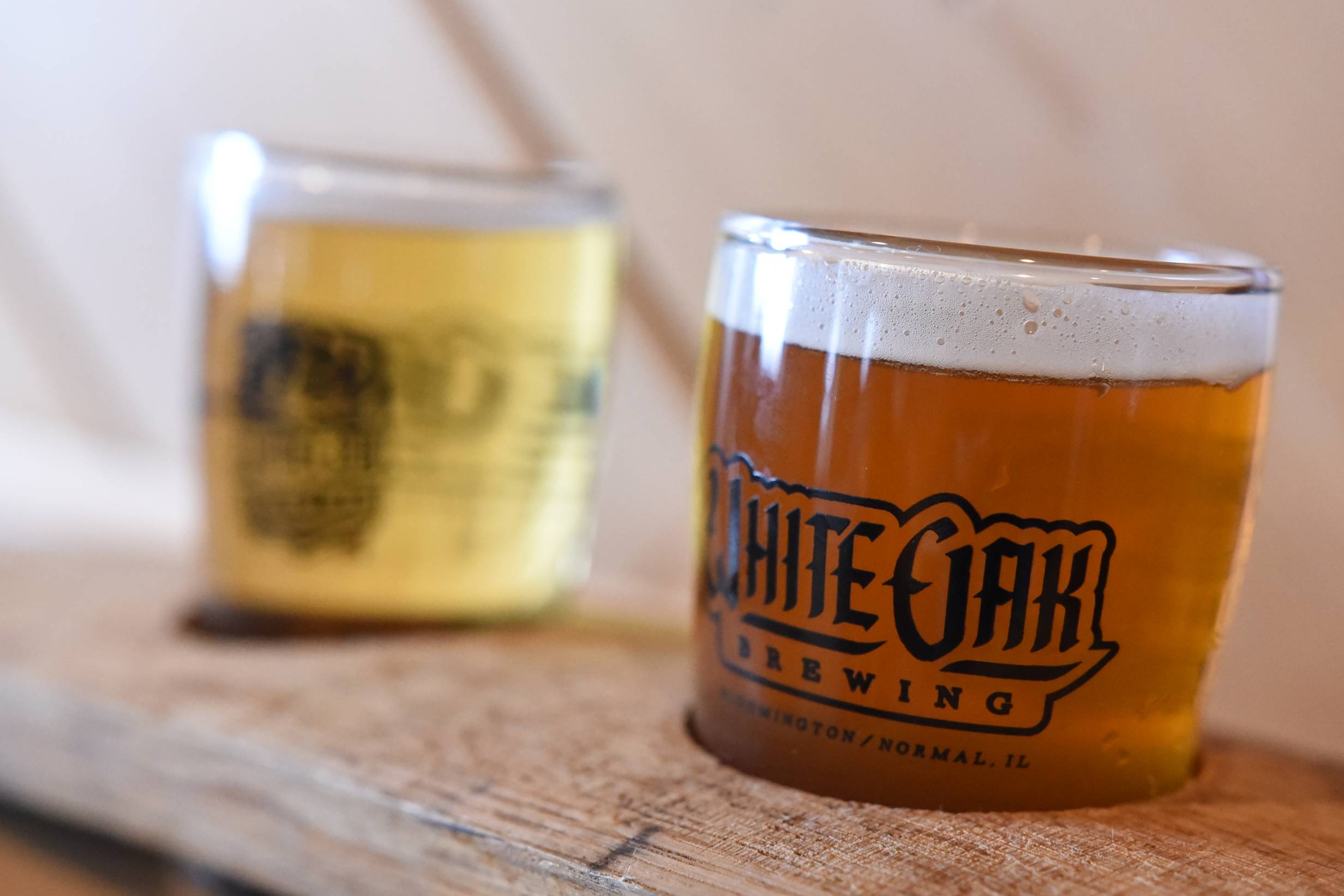 A close up image of White Oak Breweryâ€™s sour saison beer with the White Oak Cream ale in the background. Photo by Jordan Goebig.