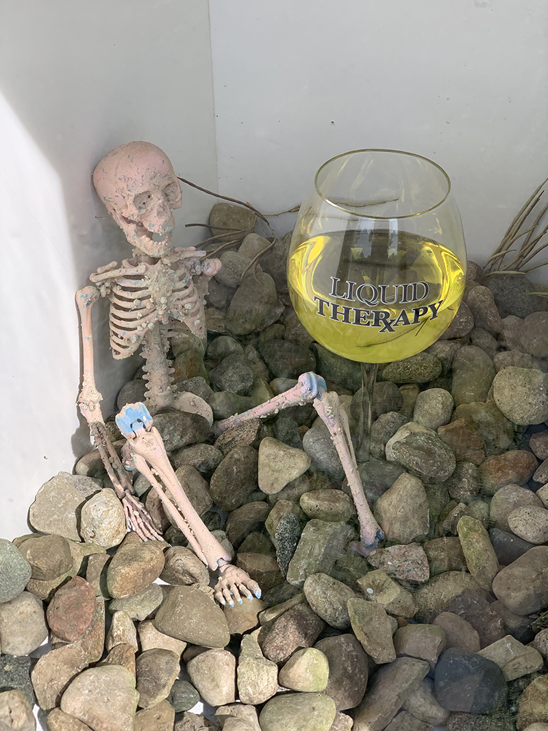 Close up interior photo of installation showing skeleton and wine glass emblazoned with 