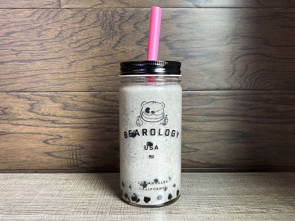 In a re-usable cup, there is a black plastic cover with a bear drawing. You can see the white color of the black sesame smoothie from Bearology. Photo by Chantal Vaca.