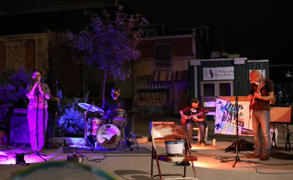 Four musicians perform at night, spread out left to right. Photo by Gabriel Solis.