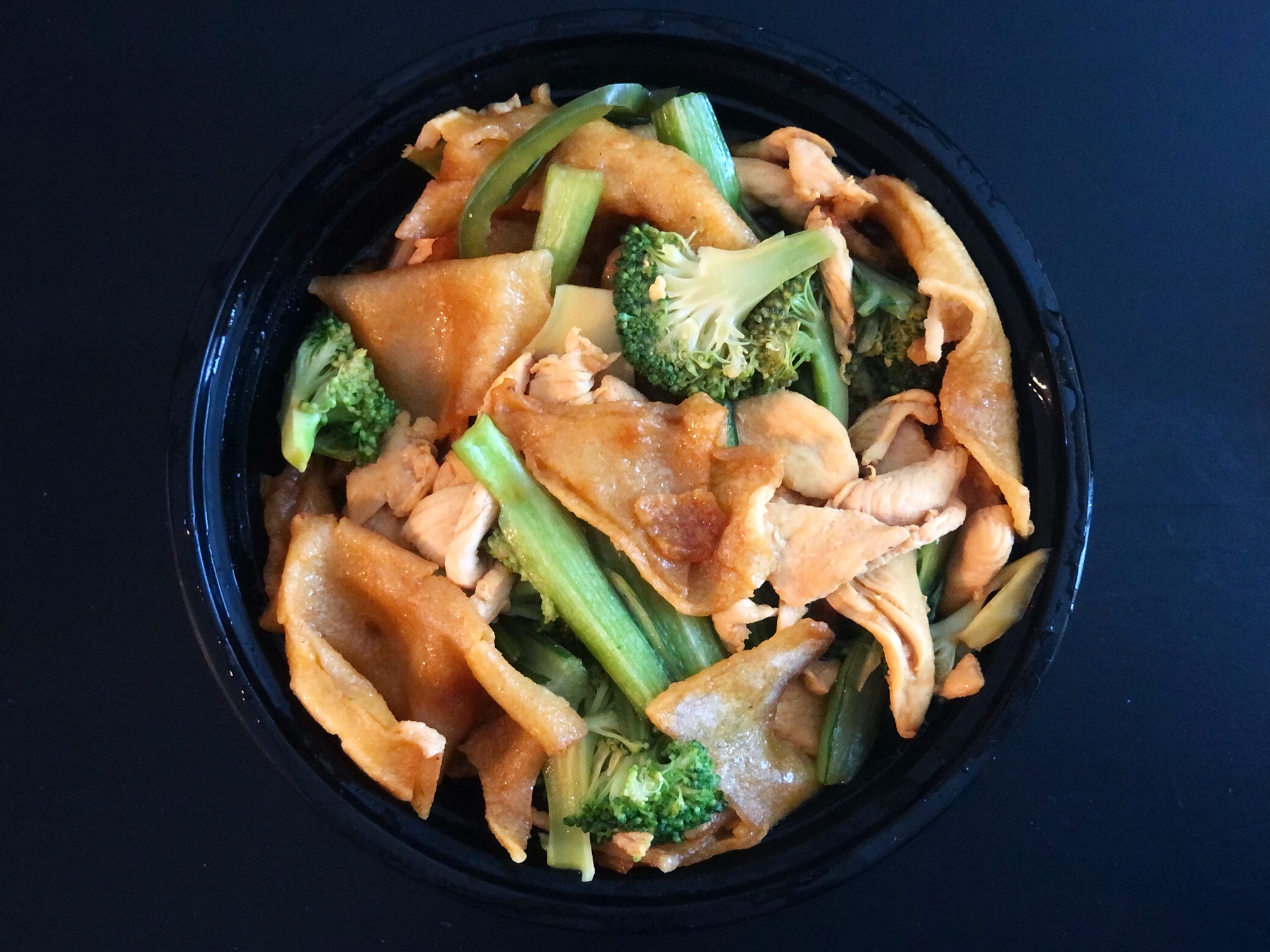 Pad Lard Nar from Sticky Rice in Champaign is filled with chicken, fried noodles, broccoli, and yu choy leaves. Photo by Alyssa Buckley.