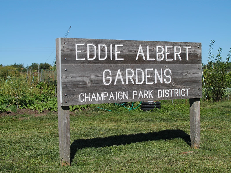 A wooden sign that states Eddie Albert Gardens